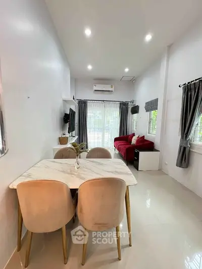 Modern living room with elegant dining area and stylish red sofa, perfect for cozy gatherings.