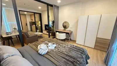 Modern studio apartment with cozy bedroom and open living area, featuring stylish decor and natural light.