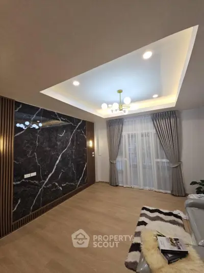 Elegant living room with modern lighting and marble accent wall