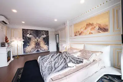 Luxurious bedroom with elegant decor and stunning wall art, featuring plush bedding and ambient lighting.