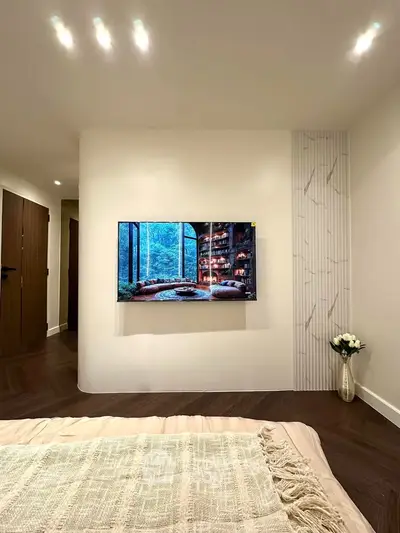 Modern bedroom with wall-mounted TV and elegant decor