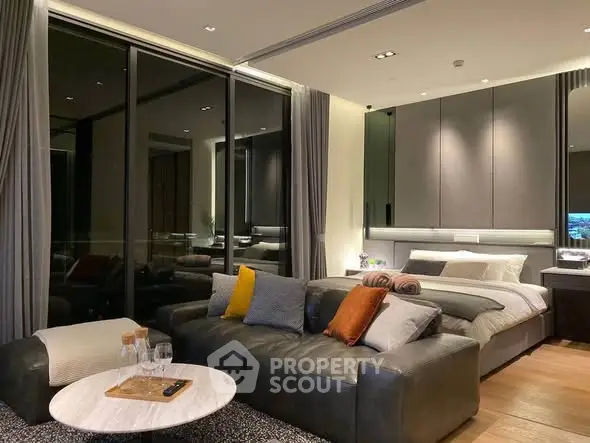 Luxurious modern living room with cozy seating and elegant bedroom area.