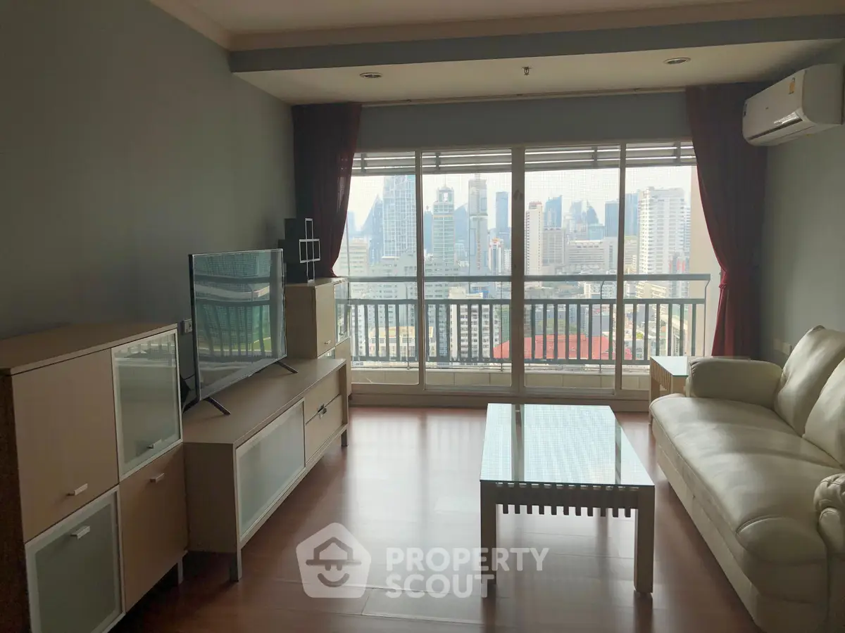 Spacious living room with city view, modern furniture, and large windows in a high-rise apartment.