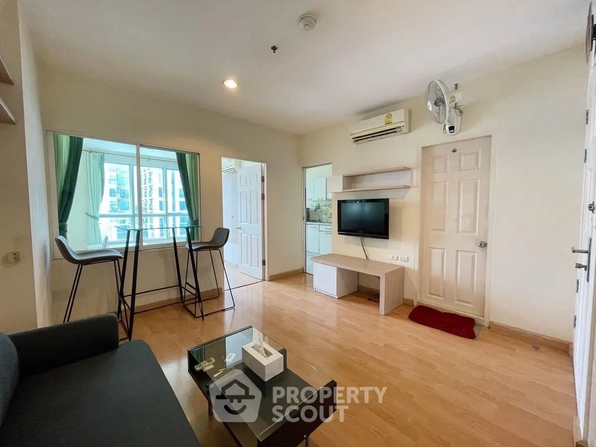 Modern living room with balcony view and sleek furniture in urban apartment.