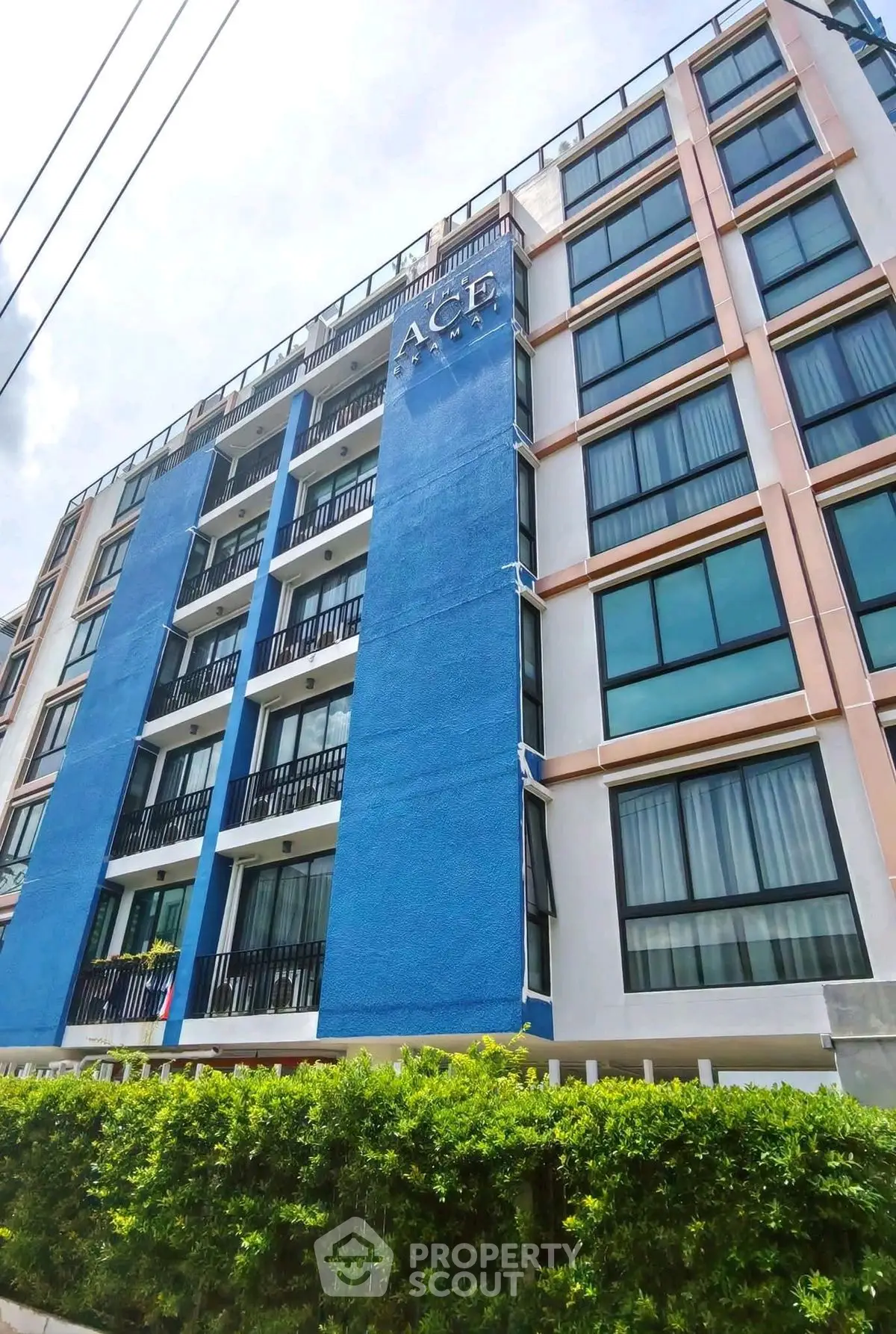 Modern apartment building with blue facade and large windows, ideal for urban living.