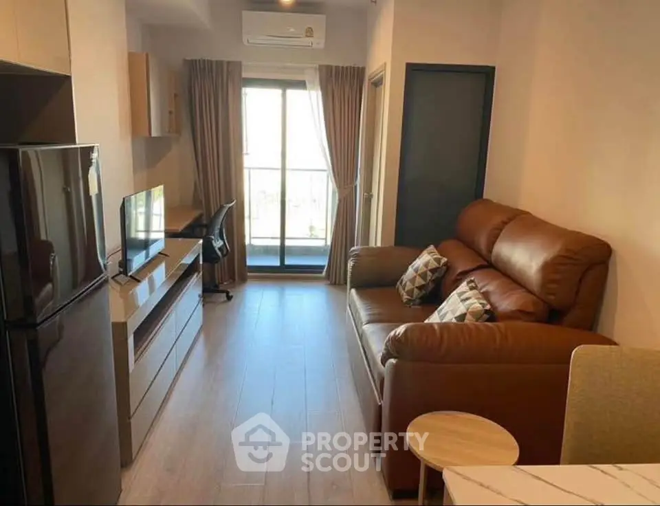 Modern living room with leather sofa, TV, and balcony view in a stylish apartment.
