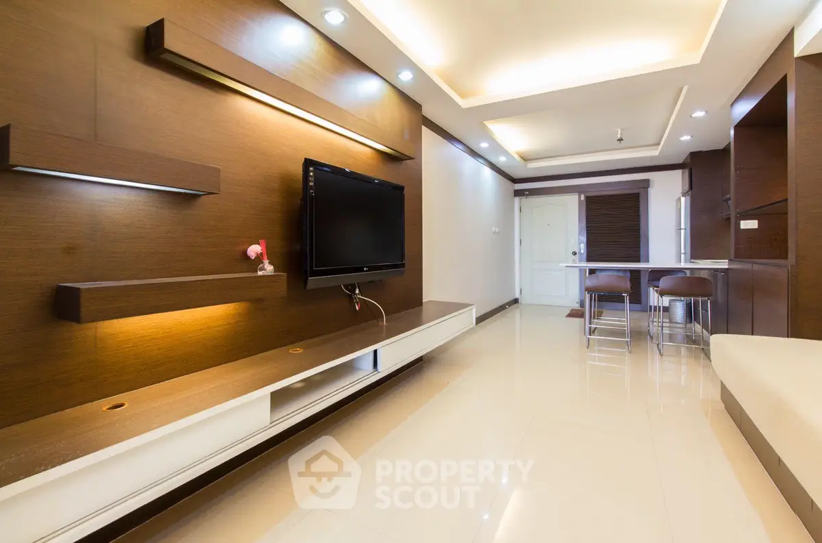 Modern living room with sleek design and open layout, featuring a wall-mounted TV and stylish lighting.