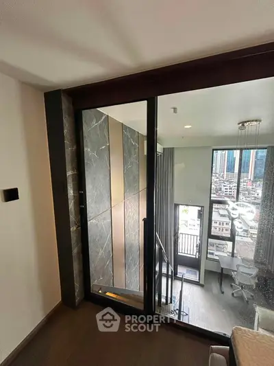 Modern duplex apartment with glass walls and city view, featuring a stylish interior and natural light.