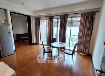 Spacious living room with wooden flooring and balcony access in modern apartment.