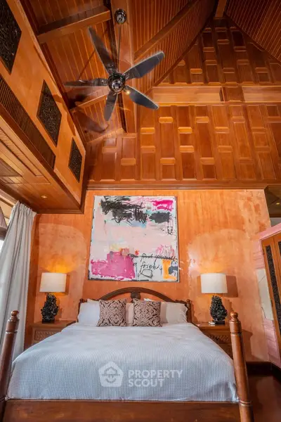 Luxurious bedroom with high wooden ceiling and modern art decor