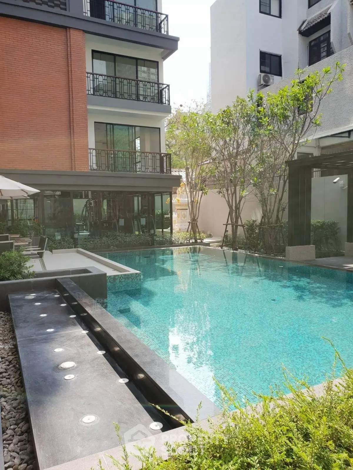 Luxurious residential pool area with modern design and lush greenery