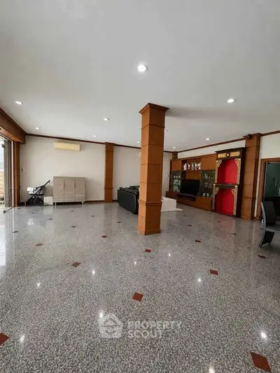 Spacious living room with polished tile flooring and elegant wooden accents