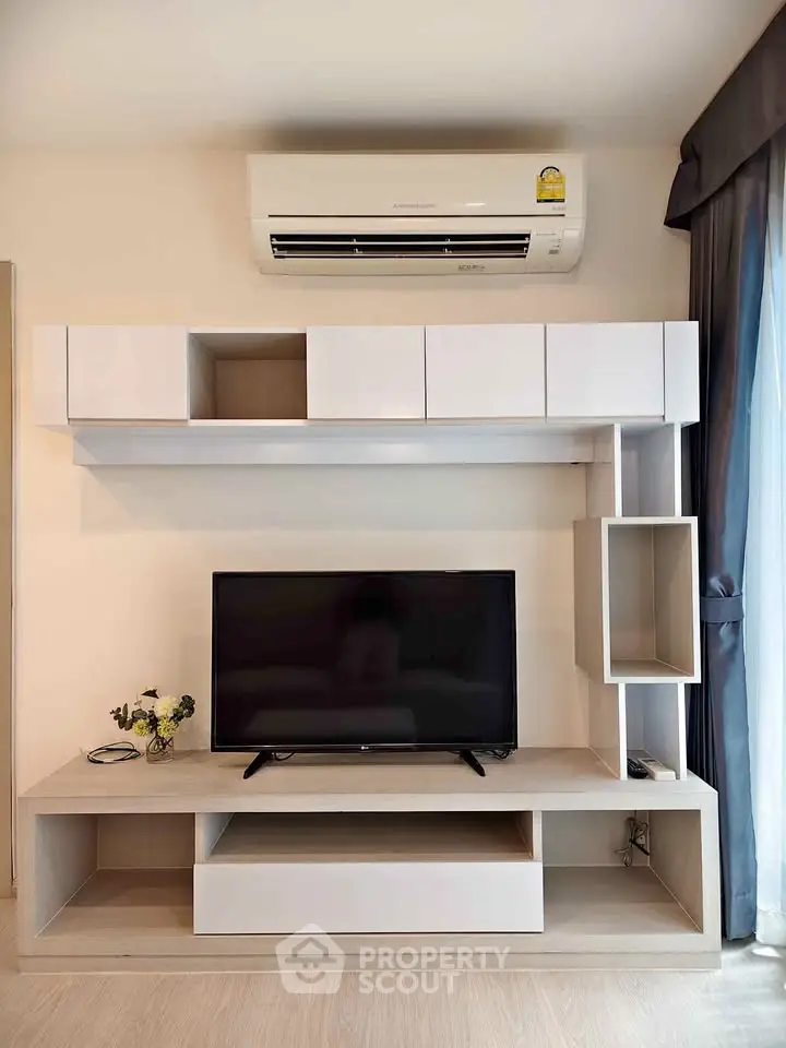 Modern living room with sleek TV unit and air conditioning, perfect for comfortable living.