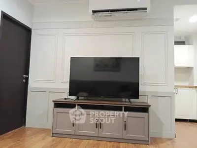 Modern living room with sleek TV setup and air conditioning unit
