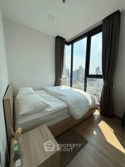 Modern bedroom with city view, featuring large windows and stylish decor.