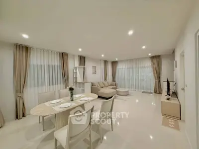 Spacious modern living room with elegant dining area and cozy seating, perfect for family gatherings.