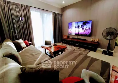 Luxurious living room with modern decor and large TV, perfect for relaxation.