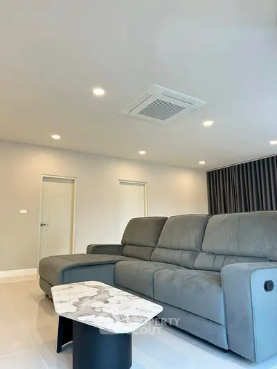 Spacious modern living room with plush gray sofa and stylish marble coffee table