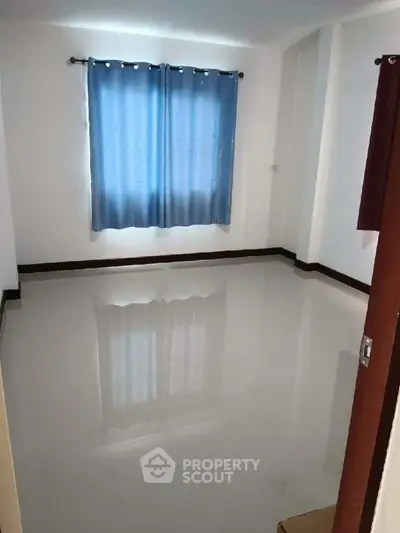 Spacious empty room with glossy white floor and blue curtains, perfect for customization.