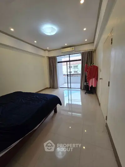 Spacious bedroom with balcony access and natural light