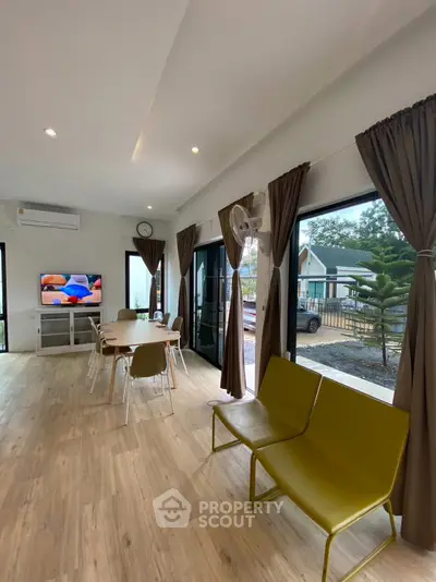 Spacious modern living room with large windows and stylish decor, perfect for family gatherings.