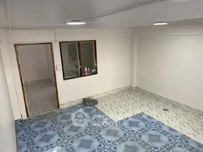 Spacious tiled room with adjacent area, ideal for versatile use in a modern home.