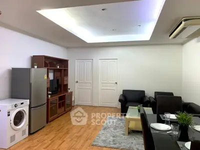 Modern living room with stylish furniture and appliances, featuring a washing machine and fridge.