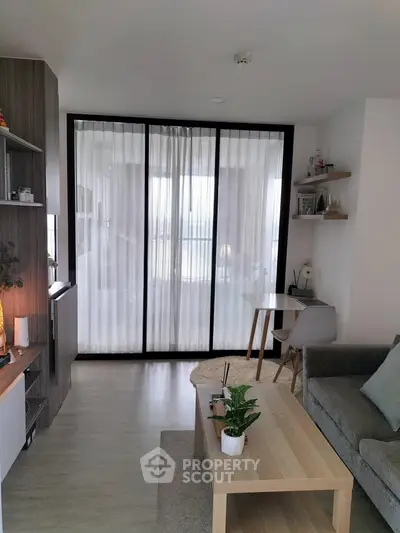 Modern living room with elegant decor and sliding glass doors leading to a bright balcony.