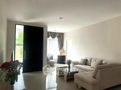 Spacious living room with modern sofa and natural light, perfect for relaxation and entertaining.