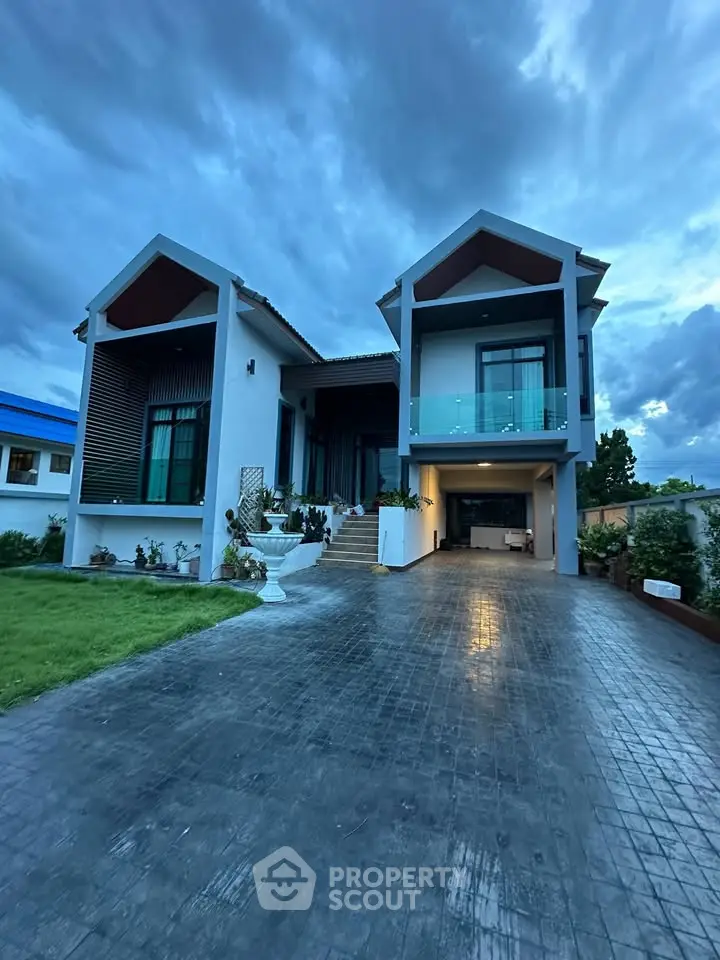 Stunning modern two-story house with elegant driveway and lush landscaping at dusk.