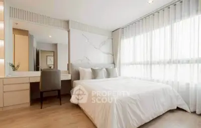 Elegant bedroom with large window and modern decor, featuring a cozy bed and stylish furniture.