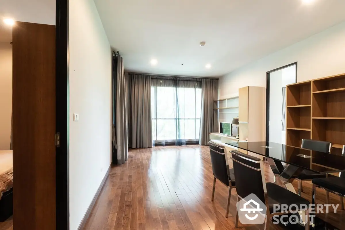 Spacious and modern living room with gleaming hardwood floors, large windows draped with elegant curtains, and a sleek dining set, perfect for entertaining.