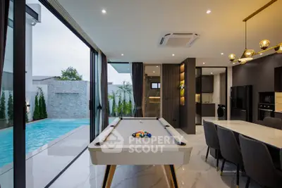 Luxurious modern living room with pool table and pool view, featuring sleek design and elegant lighting.