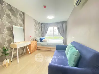 Modern bedroom with stylish decor, featuring a cozy bed, elegant sofa, and chic geometric wallpaper.