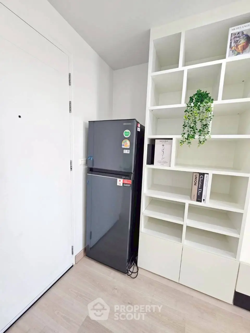 Modern kitchen corner with sleek fridge and stylish shelving unit
