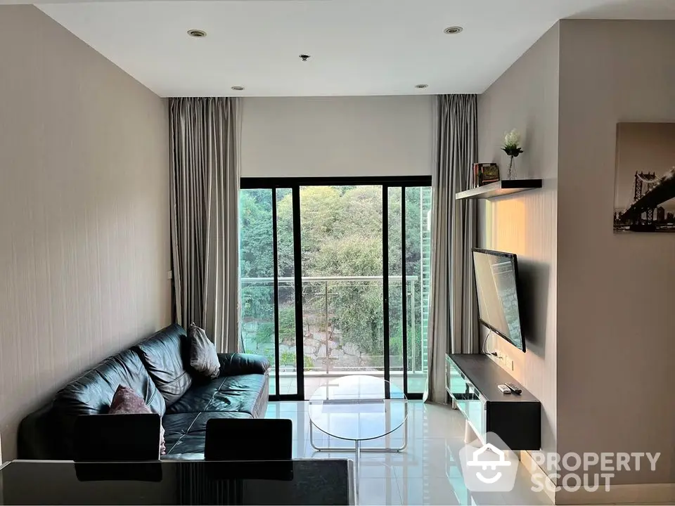 Modern living room with large window and balcony view, sleek furniture, and natural light.