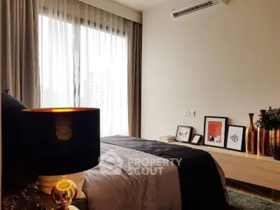 Stylish bedroom with modern decor and large window offering natural light.