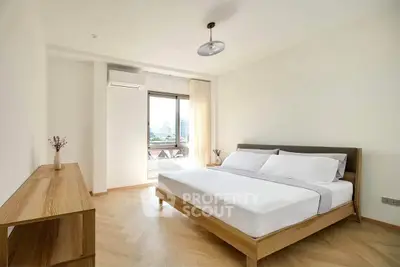 Spacious and bright bedroom with modern furnishings and city view.