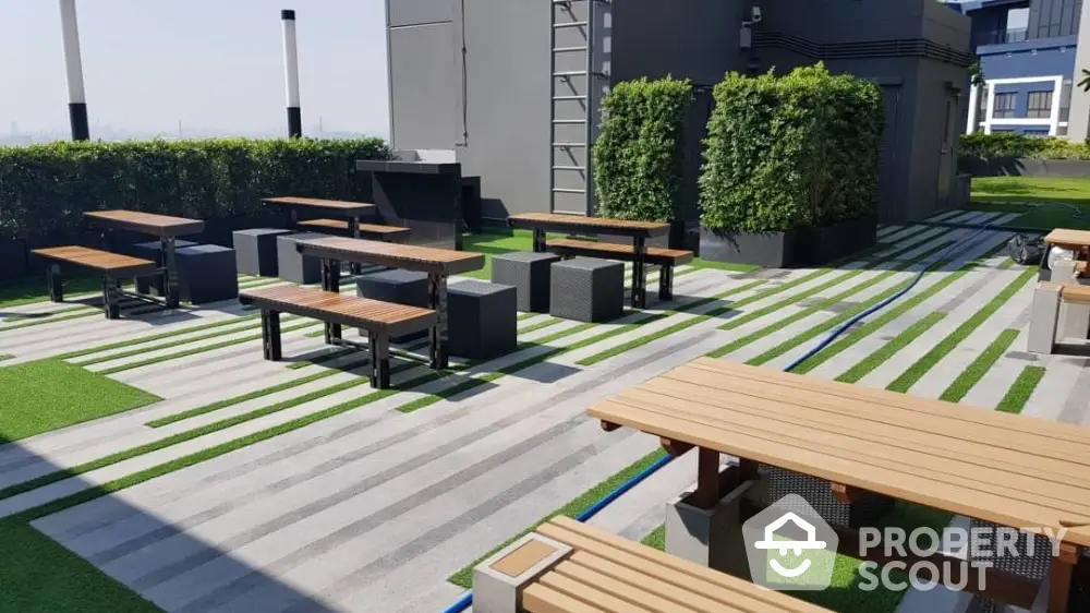 Modern rooftop garden with stylish seating and lush greenery