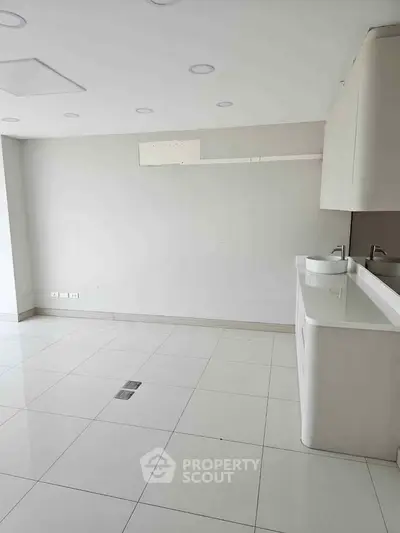 Spacious modern room with sleek white tiles and dual sinks, perfect for versatile use.