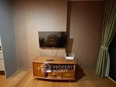 Cozy living room with mounted TV and wooden cabinet, perfect for relaxation.