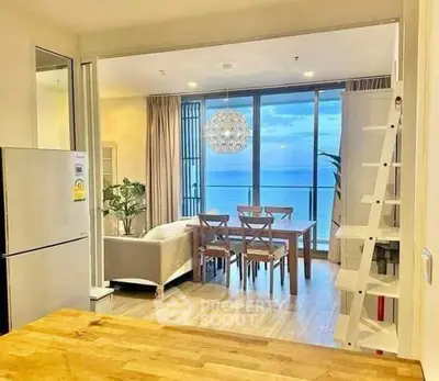 Stunning open-layout living room with ocean view, modern furniture, and elegant decor.