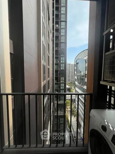 Modern urban balcony view with high-rise buildings and washing machine, ideal for city living.