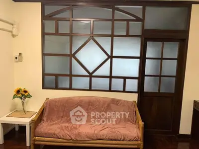 Charming living room with unique wooden window design and cozy seating area.