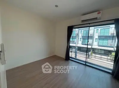 Spacious empty room with large window and air conditioning, perfect for customization.