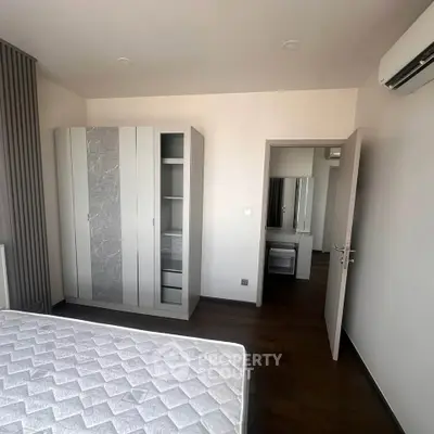 Modern bedroom with sleek wardrobe and air conditioning, featuring a comfortable mattress and stylish decor.