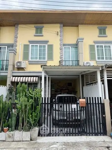 Charming townhouse with gated parking and lush cactus garden in front.