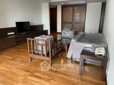 Spacious living room with wooden flooring and modern furniture in a stylish apartment.