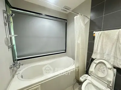 Modern bathroom with bathtub and bidet toilet in sleek design.