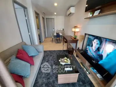 Modern living room with cozy sofa, TV, and stylish decor in a contemporary apartment.